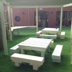 Artificial grass installed underneath picnic tables